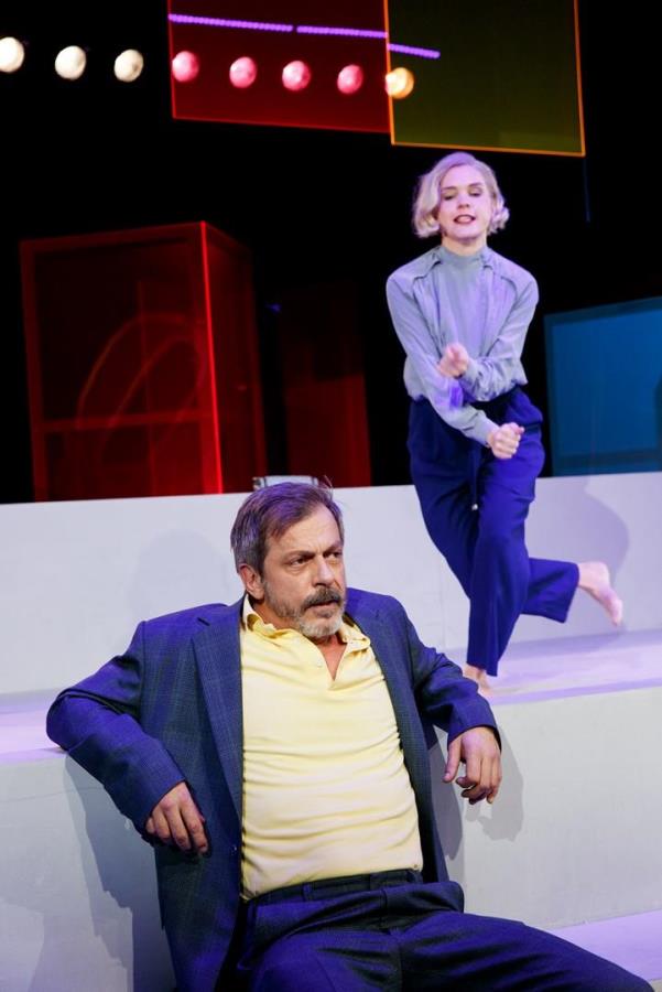 Mann sitzt auf Sofa, Frau steht hinter ihm