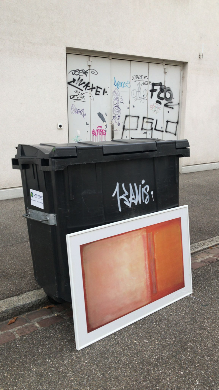 Foto von einem gerahmten abstrakten Gemälde vor einer schwarzen Mülltonne